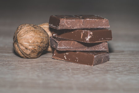 A closeup shot of a stack of chocolates with shelled walnuts