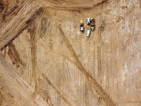 An aerial shot of road construction equipment on an open field