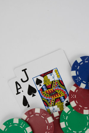 a vertical shot of  playing cards ace and jack cards and poker chips on a white backgroundの写真素材
