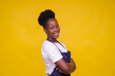 A young African-American female posing at camera on yellow backgroundの写真素材