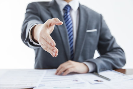The businessman in elegant suit at a business meeting giving his hand for greeting in the officeの写真素材