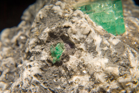 rough gemstone emeralds in granite and quartzの写真素材