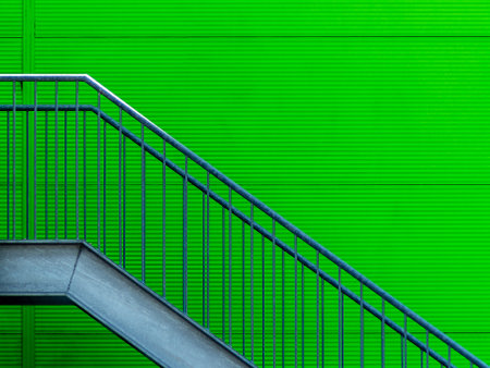 A minimalist shot of a staircase against a green wallの写真素材