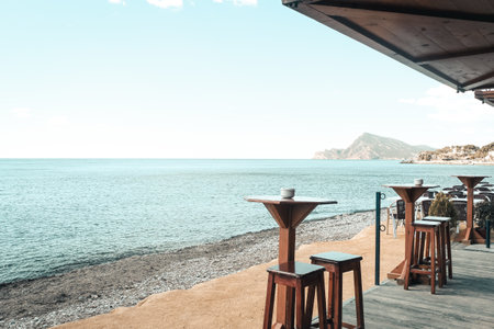 A cafe with seats and tables on the shore at daytimeの写真素材