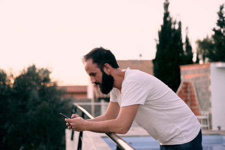 A shallow focus shot of a young caucasian male using his smartphoneの写真素材