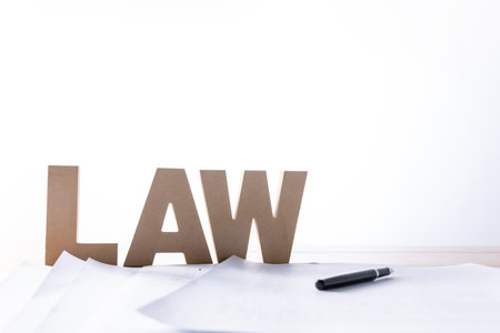 A selective focus shot of documents of the lawsuit, pen and word "Law" from wooden lettersの写真素材
