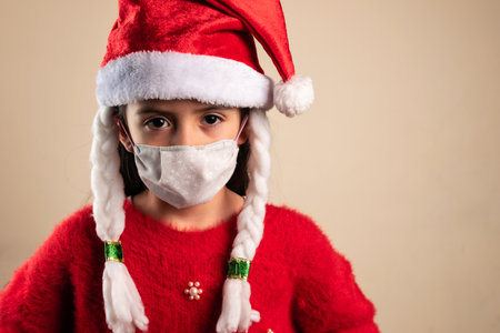 A girl wearing a Christmas hat with braids and face maskの写真素材