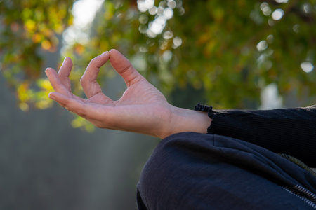 A closeup shot of a woman's hand making a mudra jnana gesture while doing a yogaの写真素材