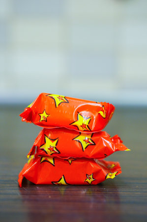 The stack of candy wrapped in red paperの写真素材