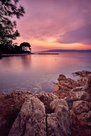 A vertical shot of the sunset at the rocky coast of the French Riviera in Franceの写真素材