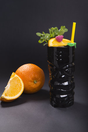 A closeup shot of a fresh orange cocktail on a black backgroundの写真素材