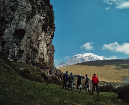 A group of hikers hiking near the mountains on a sunny dayの写真素材
