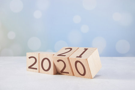 A closeup of wooden cubes with 2020 numbers changing to 2021