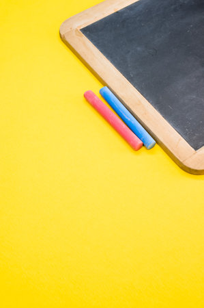 A closeup shot of the blackboard with chalk on the yellow surfaceの写真素材