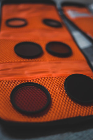 A selective focus shot of camera lens filters in an orange caseの写真素材