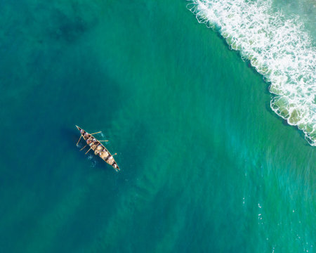 A top view shot of people in a boat fishing in Varkala Beachの写真素材