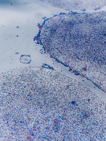 A vertical shot of blue glitter and waterdrops
