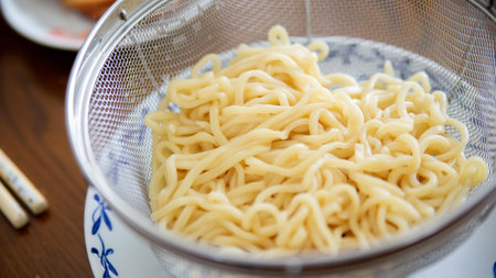 A closeup shot of cooked noodles in a colanderの写真素材