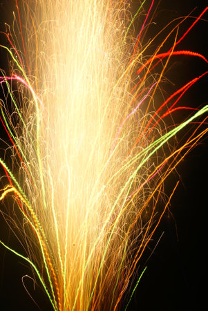 A vertical shot of bright neon firework light streaksの写真素材