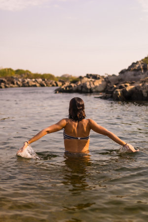 A vertical shot of a caucasian woman playing with the water near the Nubian village near the city of Aswan, in Egyptの写真素材