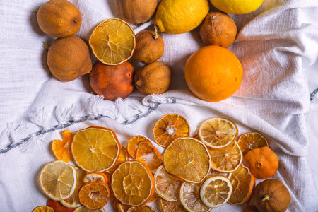 A closeup of dried orange slices and other citruses isolated on the white fabric - orange and tangerineの写真素材