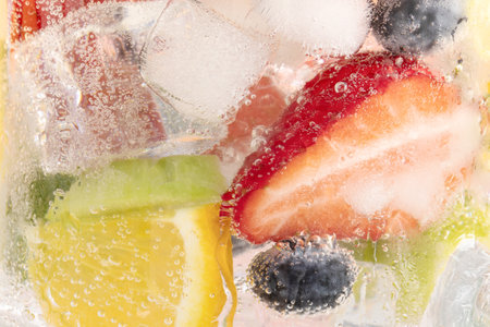 A closeup shot of a refreshing drink with sliced fruits and ice cubesの写真素材