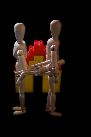 A vertical shot of wooden mannequins of a family isolated on a black background - divorce conceptの写真素材