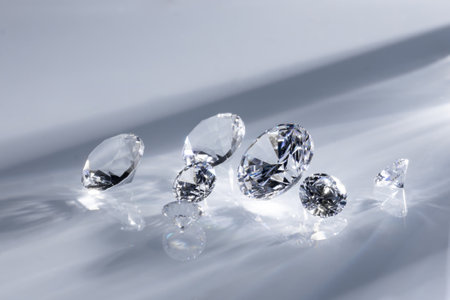 A closeup shot of beautifully cut diamonds on a white surfaceの写真素材