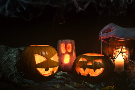 A closeup of decorated Halloween pumpkin head jacks with candlesの写真素材