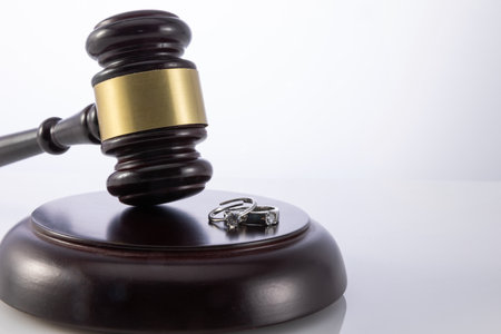 A closeup shot of the judge's gavel with wedding rings - concept of divorceの写真素材