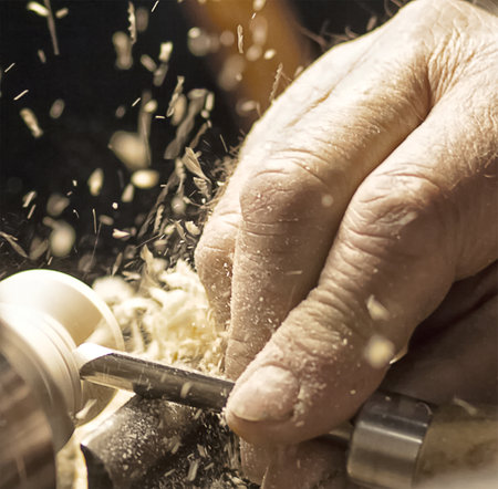 A carpenter working with a machine and splinters all around