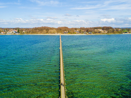 The endless looking wooden pier on the North Sea under the blue cloudy skyの写真素材