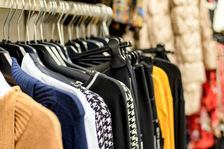 A closeup shot of various clothes on hangers in a storeの写真素材