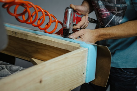 A closeup shot of a male working in a furniture factory