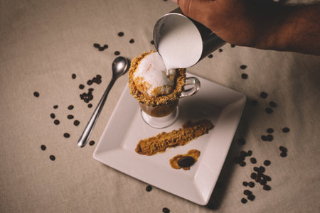 A high angle shot of frothy milk being poured into a gourmet latteの写真素材