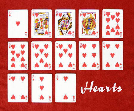 A top view of a deck of hearts playing cards in order from high to low on a red background