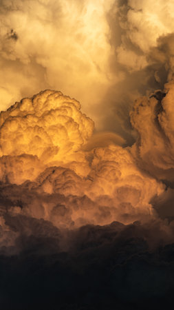 A fantastic vertical panoramic view of a heavily clouded dramatic sky illuminated by sunlight at duskの写真素材