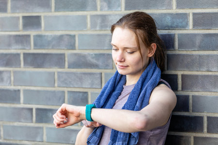 A young woman looking at her fitness watch during the fitness workout