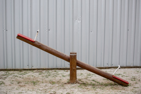 A wooden seesaw in a playground at daytime