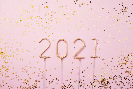 A top view of golden "2021" made of sparkler fireworks and surrounded by starsの写真素材