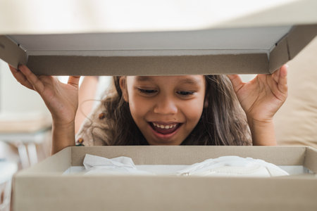 A framed photo of a cute girl opening a box.