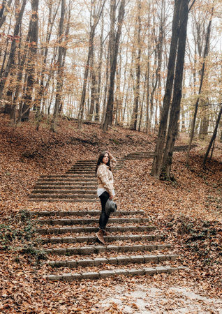 A shot of a woman posing in an autumn forestの写真素材