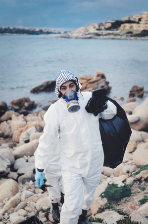 A shallow focus shot of a  female in special uniform cleaning the beachの写真素材