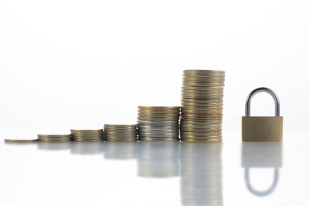 A closeup shot of stacks of coins and a padlock - concept of financial security