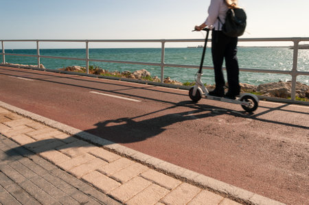 A closeup shot of a female riding a scooter near the seaside