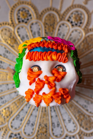 A vertical shot of a sugar skull for the colorful Day of the Dead on a patterned surfaceの写真素材