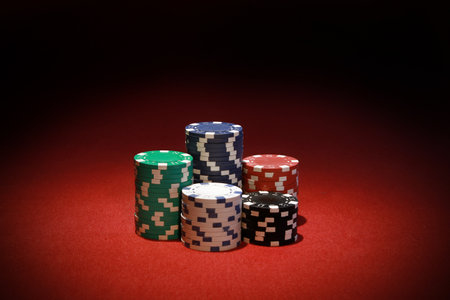 The stacks of colorful poker chips on a red table