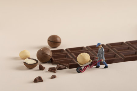 A closeup shot of small construction workers working on a bar of chocolate