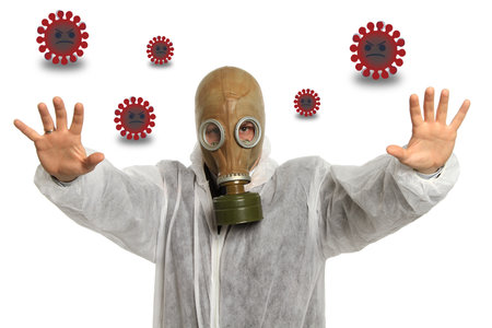 A person wearing a protective coat and a gas mask while stopping the COVID-19 cellsの写真素材