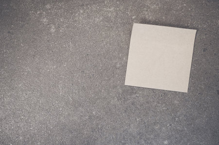 A top view of a blank paper memo on a rough-textured surface with copy spaceの写真素材